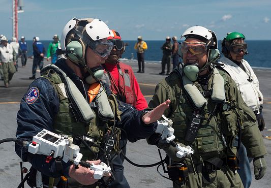 Dave Lorenz, left, and Bruce McFadden, deck operators for Northrop Grumman, discuss the launch of an X-47B Unmanned Combat Air System (UCAS) demonstrator on the flight deck of the aircraft carrier USS George H.W. Bush (CVN 77). Lorenz and McFadden operated the X-47B as it taxied from the aircraft elevator to the catapult. George H.W. Bush is the first aircraft carrier to successfully catapult launch an unmanned aircraft from its flight deck. (U.S. Navy photo by Mass Communication Specialist 2nd Class Timothy Walter/Released)